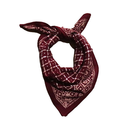 Maroon bandana with white geometric pattern on a white background
