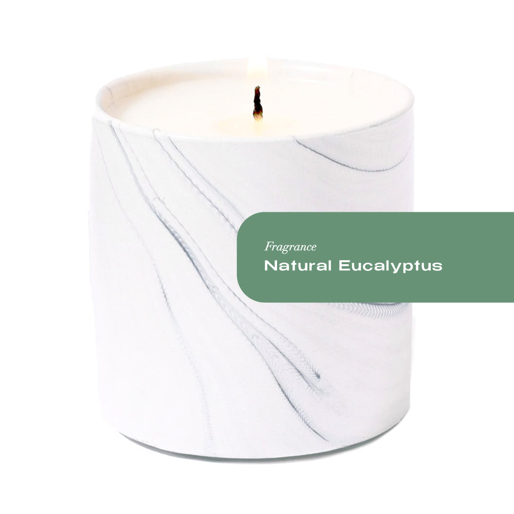 White candle with a label indicating 'Fragrance Natural Eucalyptus' on a white background