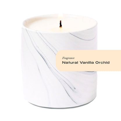 White candle with a label indicating 'Fragrance: Natural Vanilla Orchid' on a white background