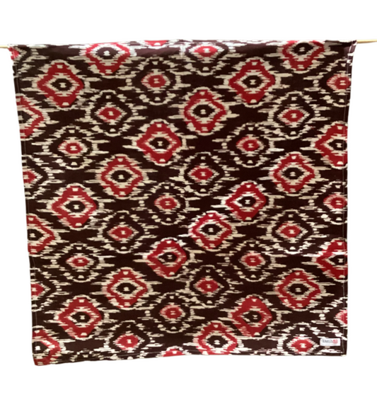Fabric with a red and black pattern draped over a white background