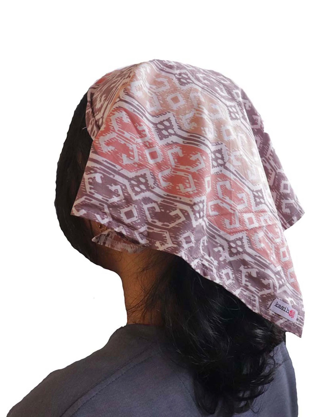 Person wearing a patterned headscarf on a white background